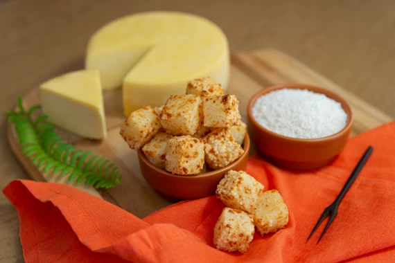 dadinho de tapioca com um pote de tapioca e um pedaço de queijo canastra
